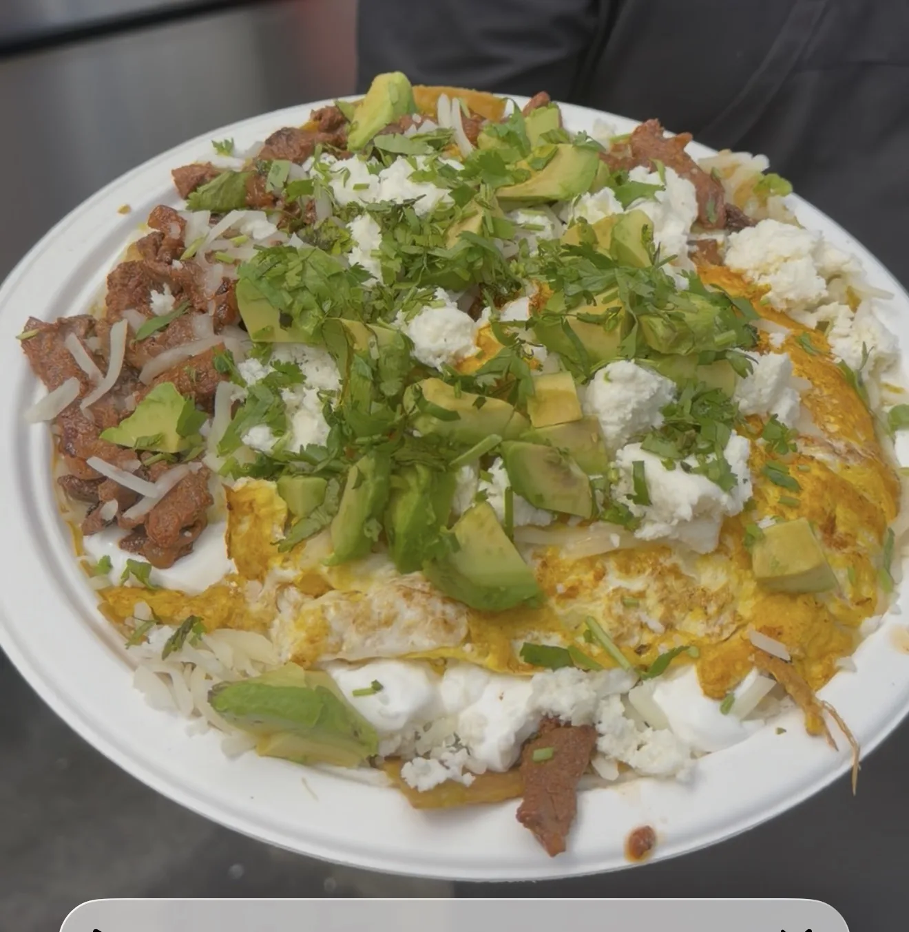 Chilaquiles with carne asada, avocado, cheese and cilantro