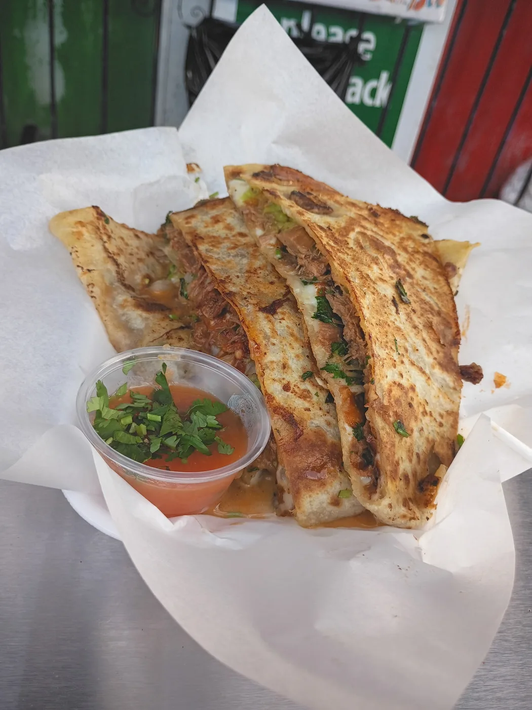 Grilled meat quesadilla cut into wedges with salsa