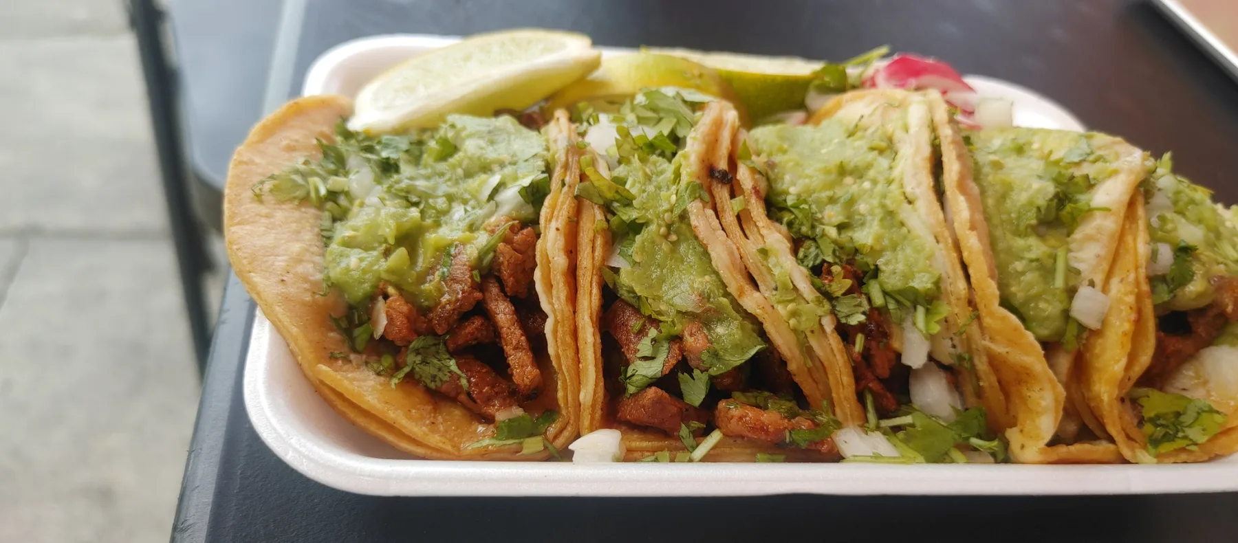 Fresh tacos with carne asada, guacamole, cilantro and onion